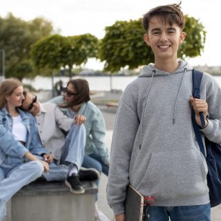 portrait-boy-holding-skateboard-his-friends